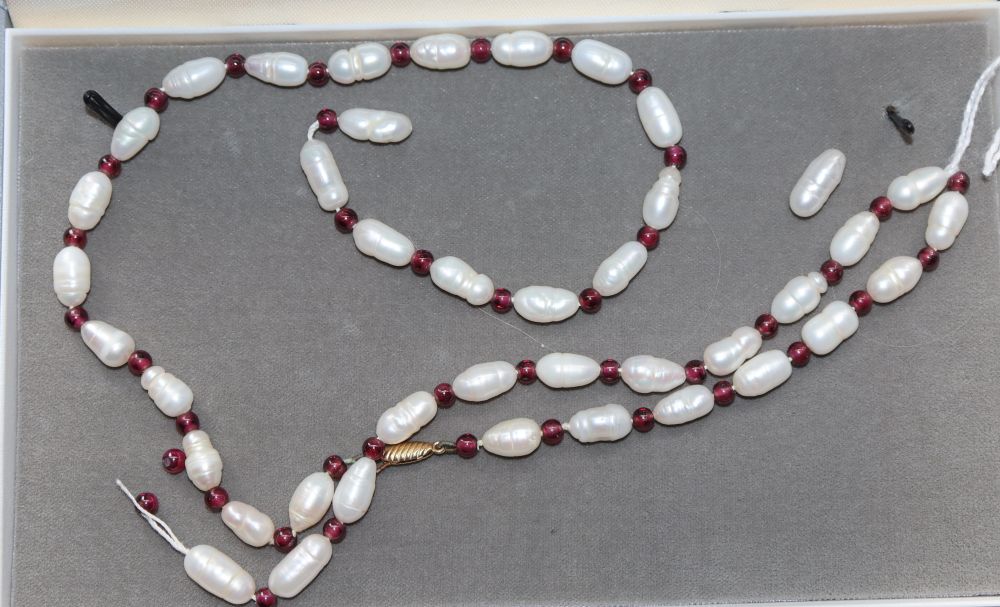 A modern single strand river baroque pearl and garnet bead necklace, (string broken), 63.5cm.